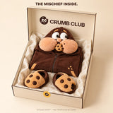 Packaging concept: a folded Goinfre onesie and separate cookie slippers in a Crumb Club box. Final presentation may change.